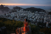 A woman poses for a photo during sunrise at Dona Marta lookout point in Rio de Janeiro