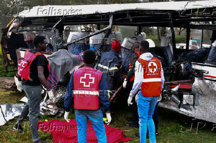 Kenya Red Cross and other rescuers attempt to remove the body of a passenger from the wreckage of a staff bus that collided at a railway crossing in Naivasha
