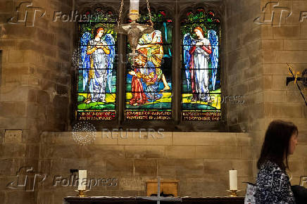 A visitor stands inside the Harvard Chapel at Southwark Cathedral in London