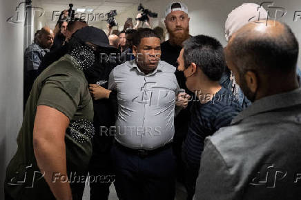A migrant is detained by federal immigration officers at U.S. immigration court