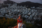 A woman poses for a photo during sunrise at Dona Marta lookout point in Rio de Janeiro