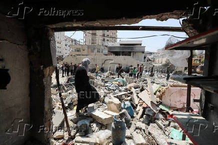 Palestinians inspect the damage at the site of an Israeli strike on a house, in Gaza City