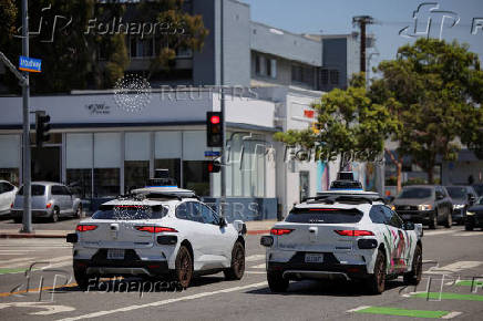 FILE PHOTO: Waymo driverless vehicles wait at a traffic light in Santa Monica