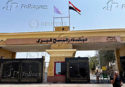 People stand at the Rafah border crossing between Egypt and the Gaza Strip, in Rafah
