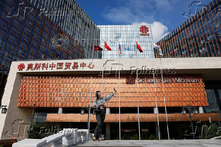A woman takes a selfie in front of the Soluxe Hotel in a Chinese business centre in Moscow