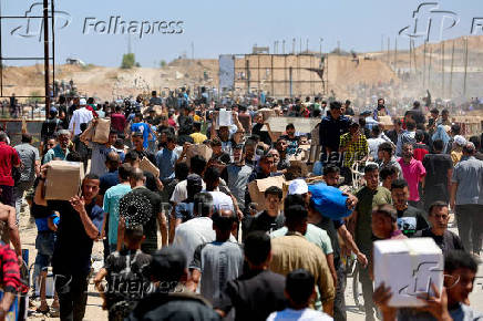 FILE PHOTO: Palestinians carry aid supplies which they received from the U.S.-backed Gaza Humanitarian Foundation
