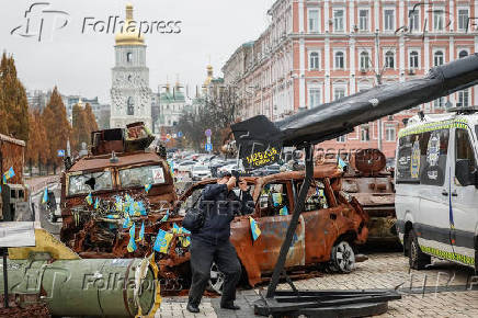 A man takes pictures of a destroyed Russian combat drone at the exhibition displaying destroyed Russian military vehicles in Kyiv