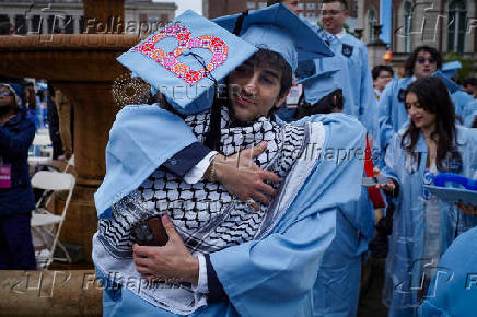 Graduating students embrace during Columbia University's commencement ceremony on its main campus, in Manhattan, New York City