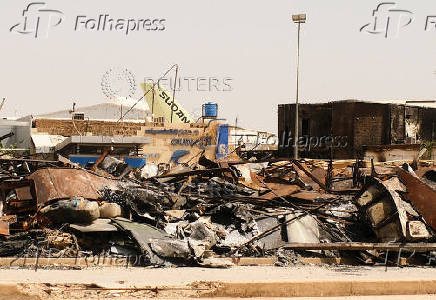 A view of a burned building and the tail of a Sudan Airways aircraft amid debris at Khartoum Airport, in Khartoum