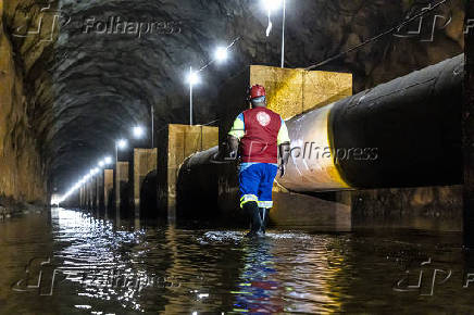 Funcionário da Sabesp inspeciona sistema de água em túnel subterrâneo