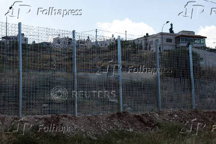Israeli authorities encircle Palestinian town in West Bank with a fence, restricting free movement of residents