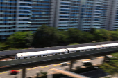 A Mass Rapid Transit (MRT) train passes public housing apartments in Singapore