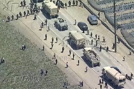 A military convoy enters the area during an immigration raid on an agricultural facility in Camarillo