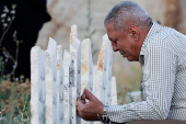 Palestinians visit graves of their relatives at a cemetery in Jenin camp
