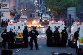 Armed police in riot gear stand guard during a second night of riots, in Ballymena