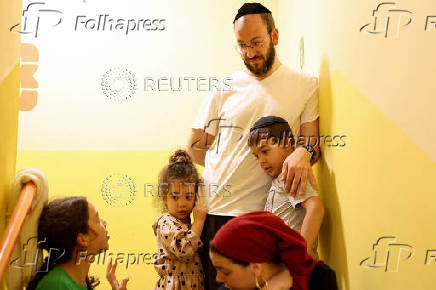 People take shelter during a siren as missiles are launched from Iran towards Israel