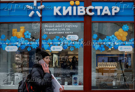 FILE PHOTO: A woman walks past a Kyivstar store in Kyiv