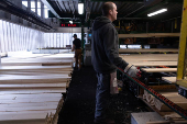 Employees remove finished wood products from the production line inside the sawmill at Gorman Bros. Lumber Ltd. in West Kelowna