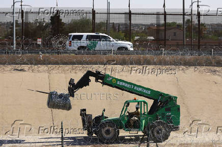 Members of the U.S. military replace concertina wire at on the U.S.-Mexico border, as seen from Ciudad Juarez