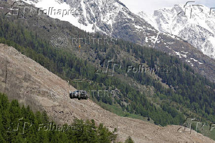 A car is carried by helicopter near Blatten