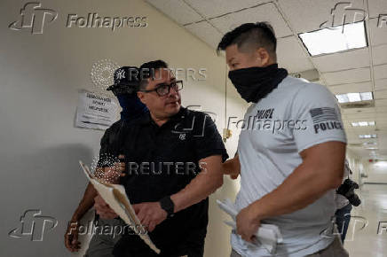 A migrant is detained by federal immigration officers at U.S. immigration court
