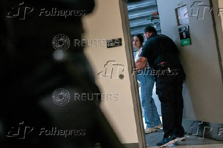 A migrant is detained by federal immigration officers at U.S. immigration court