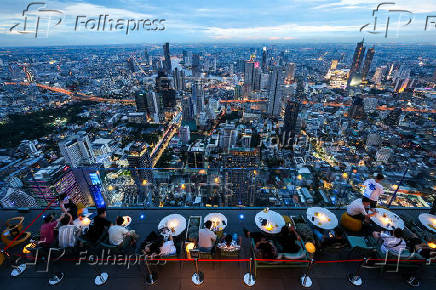 Tourists enjoy a view at the Mahanakhon Skywalk rooftop in Bangkok