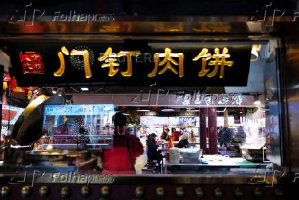 People sit in a restaurant at the Nanluoguxiang in Beijing