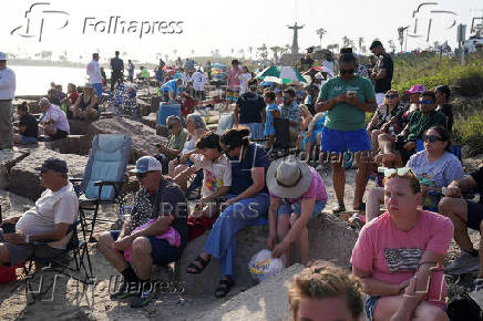 People wait to watch SpaceX's next-generation Starship spacecraft atop its Super Heavy booster launch