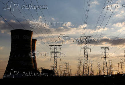 FILE PHOTO: Electricity pylons are seen along the cooling tower of the defunct Orlando Power Station in Soweto