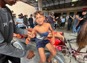 Casualties are transported after Palestinians were wounded by Israeli fire near an aid center, according to medics, in Khan Younis