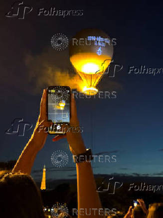 A message in support of Palestinians in Gaza is projected onto the hot air balloon holding the the Vasque (cauldron) of Paris 2024 non-Olympic flame in Paris