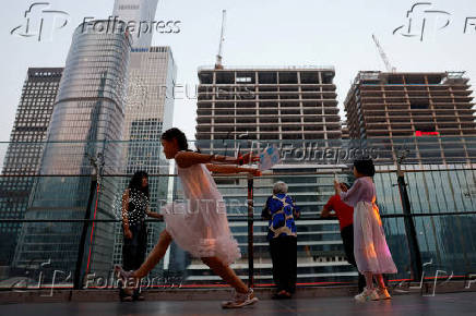 People visit a terrace of a shopping mall overlooking the central business district (CBD), in Beijing
