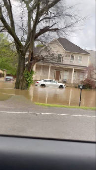 Cars parked outside a house are partially submerged in flood water after flash floods in Nashville, Tennessee