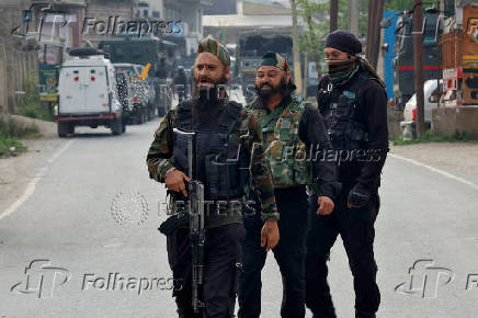 Indian security force personnel stand guard near the site of a fighter jet crash in Wuyan