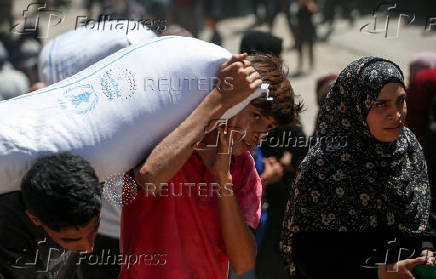 Palestinians gather to receive aid at a distribution center, in Gaza City