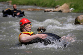 Sports enthusiasts compete while floating on inner tyre tubes during the tyre festival 'Bunar Fest' in Prizren