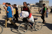 Palestinians seeking aid gather near an aid distribution site run by the U.S.-backed Gaza Humanitarian Foundation, in Rafah