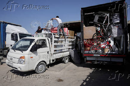 Syrian returnee Ahmed Al-hadid, and his family members load belongings onto a truck, in Aleppo's countryside