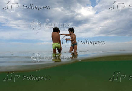 Boys enjoy Sao Conrado beach during the World Oceans Day, at Sao Conrado beach in Rio de Janeiro