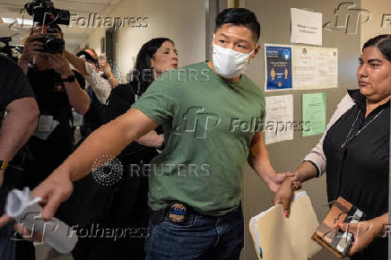 A migrant is detained by federal immigration officers at U.S. immigration court