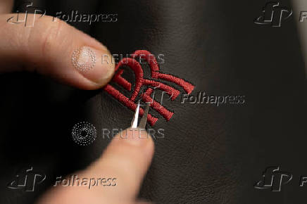 A technician repairs the logo by hand at the leather workshop line for Rolls-Royce vehicles at Rolls-Royce Motor Cars' manufacturing plant in Goodwood