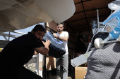 Syrian returnee Ahmed Al-hadid, and his family members load belongings onto a truck, in Aleppo's countryside