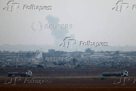 Trucks loaded with aid drive on the Israel-Gaza border as they make their way into Gaza