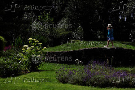 A girl walks in a garden of flowers, in Lullymore