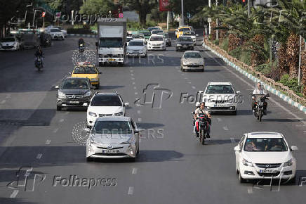 Cars move along a street in Tehran