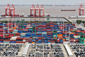 Drone view shows electric vehicles (EV) for export and containers sitting at a port in Shanghai