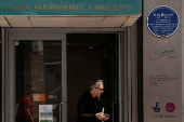 A person walks out the John Harvard blue plaque outside the John Harvard Library on Borough High Street, London