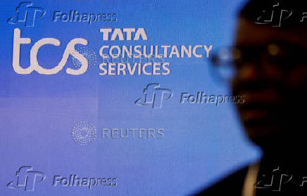 FILE PHOTO: FILE PHOTO: A man walks past a logo of Tata Consultancy Services (TCS) before a press conference announcing the company's quarterly results in Mumbai