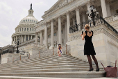 A graduate has her photo taken at the U.S. Capitol in Washington